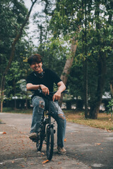Young handsome bearded man taking a break while travelling the city with his bicycle using his digital tablet looking away thoughtfully