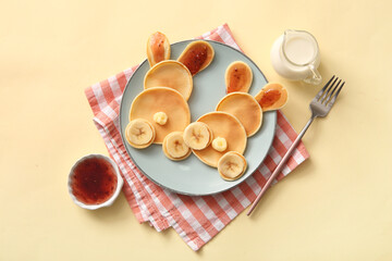 Funny Easter bunny pancakes with banana and jam on yellow background