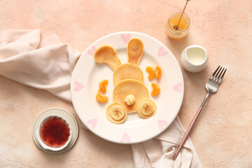 Funny Easter bunny pancakes with mandarin on beige background