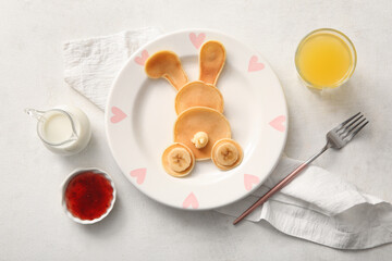 Funny Easter bunny pancakes with glass of orange juice on white background