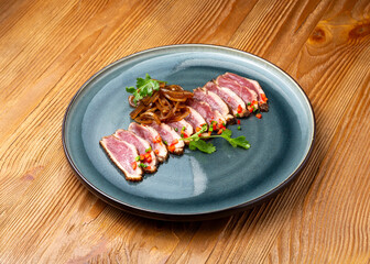 Roast beef from duck meat in a plate on a wooden background
