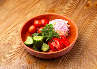 Homemade pickles, tomatoes, cabbage in a plate on a wooden background