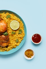 Bowl of traditional chicken biryani on blue background