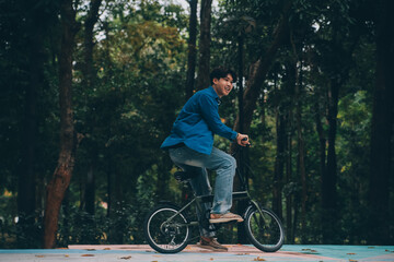 Fototapeta premium Young handsome bearded man taking a break while travelling the city with his bicycle using his digital tablet looking away thoughtfully