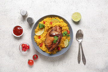 Bowl of traditional chicken biryani with ingredients on white table