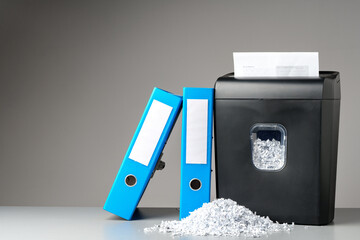 Office paper shredder on table against gray background