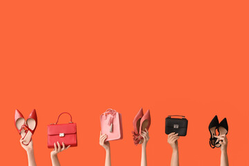 Women with stylish shoes and bags on orange background