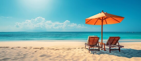 Gorgeous chairs with umbrella on sandy tropical beach.