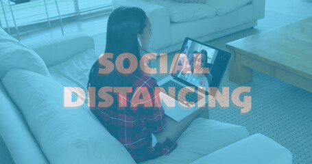 Image of social distancing text over woman using laptop on image call