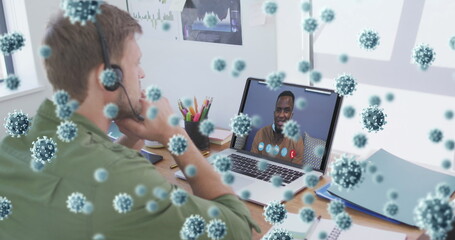 Image of covid 19 cells over man in face mask using laptop on image call - Powered by Adobe