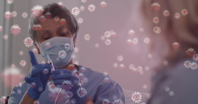 Image of covid 19 cells over female nurse preparing vaccination wearing face mask - Powered by Adobe