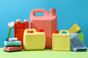 On a blue background, colorful empty canisters decorated with cleaning equipments. Plastic...