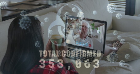 Image of covid19 cells and number of cases over woman using laptop on image call