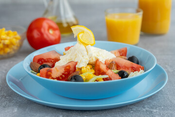 Colorful fresh vegetable salad with mozzarella cheese in bowl and orange juice. Healthy food concept