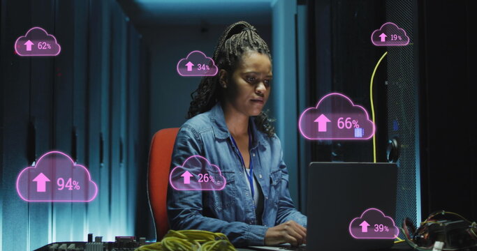 Image of cloud with uploading over african american woman working on laptop in server room