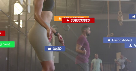 Image of social media notifications over diverse woman and man jumping rope at gym
