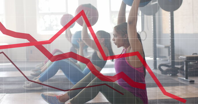 Image of graph processing data over diverse women cross training with medicine balls at gym
