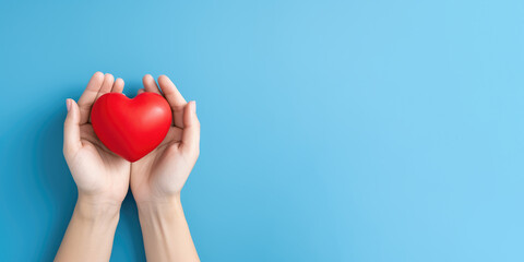 Hand hold red heart on blue background for organ donor awareness, world heart day , a valentines day