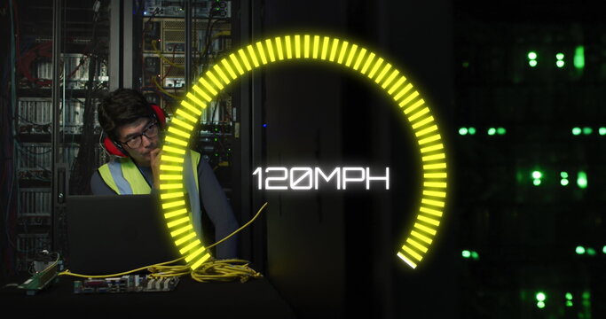 Image of speedometer over biracial man using laptop in server room