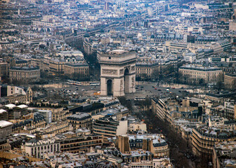 An aerial view of Arc de Triomphe and the city of Paris from the top of the Eiffel Tower