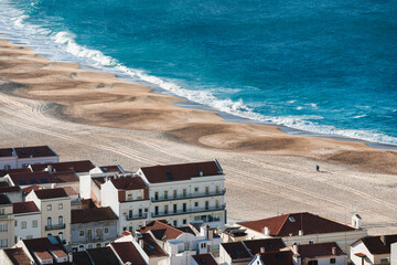 Fototapeta na wymiar View of the sandy beach and Atlantic ocean in Nazare, Portugal.