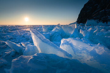 Blue ice on Baikal lake at sunrise. Khoboy cape of Olkhon island, Baikal, Russia.
