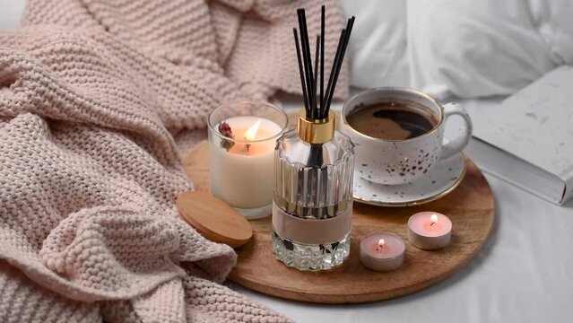 Aroma scented reed diffuser glass is on the tray with scented candle