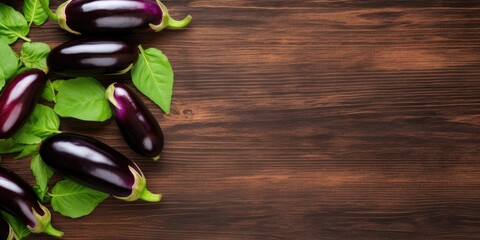 Fresh, glossy eggplant on wood table, flat lay with room for text.