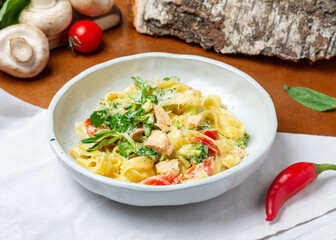 Italian pasta with salmon in a plate on a wooden background