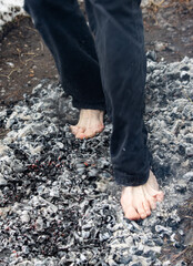 people walk with their feet on hot coals as a background.