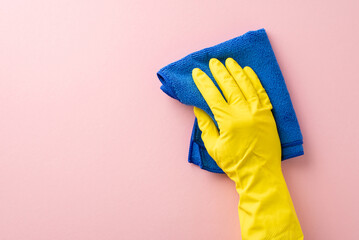 A first-person perspective photo featuring a hand in a rubber glove, using a soft cleaning cloth on a gentle pink background, perfect for housecleaning ads with space for text - obrazy, fototapety, plakaty