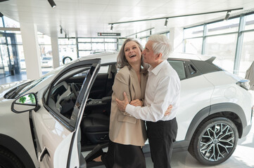 Mature Caucasian couple hugging. Elderly man and woman buying a new car. 