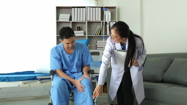A caring female doctor provides medical care to a male patient in a wheelchair who has knee and ankle pain due to overwork. Shock received medical attention from doctors at the hospital.