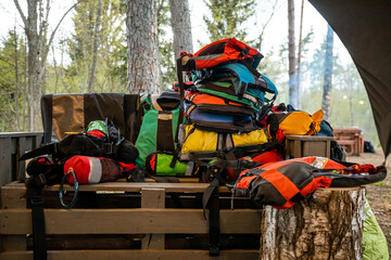 pile of colorful backpacks and camping gear neatly stacked, preparing for an outdoor adventure in...