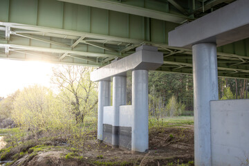Fragment of a road bridge across the river, an iron structure on a concrete support.