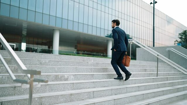 Successful business man celebrate increasing sales while walking at stairs. Project manager or leader proud with successful project, getting a promotion, getting a job. Overjoy and happy. Exultant.