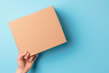 Top view to female hand holding brown cardboard box on light blue background. Mockup parcel box. Packaging, shopping, delivery concept, Generative AI 