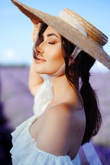 Lavender field.portrait young girl in lavender.straw hat  with closed eyes in lavender field