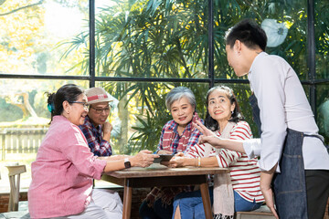 Restaurant eatery shop, Asian senior women having fun searching menus from tablet computer learning to order food by modern application, elderly pension females happy friendly with wireless technology