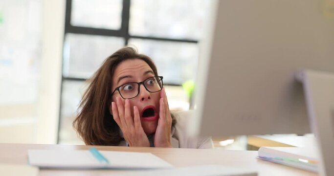 Business woman looking out from behind her desk in office