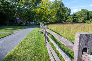 Split rail fence along country gravel road with pasture idyllic country scene