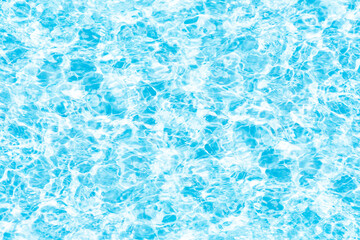 Water surface. Bluewater waves on the surface ripples blurred. Defocus blurred transparent blue colored clear calm water surface texture with splash and bubbles. Water waves with shining pattern.