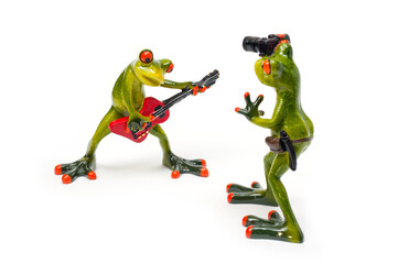 Decorative figures of frogs, a frog with a red guitar and a frog with a camera.