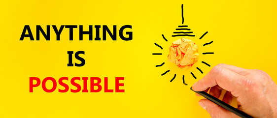 Anything is possible symbol. Concept words Anything is possible on beautiful yellow paper. Beautiful yellow background. Light bulb icon. Businessman hand. Business anything possible concept Copy space