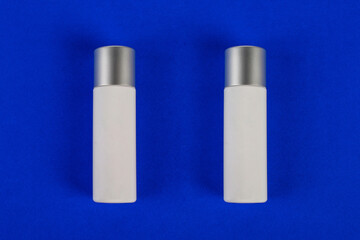 Plastic white tube for cream or lotion. Skin care or sunscreen cosmetic on blue background 