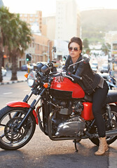 Fototapeta na wymiar Motorcycle, leather and woman in city with sunglasses for travel, transport or road trip as rebel. Fashion, street and model with attitude on classic or vintage bike for transportation or journey