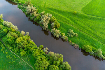 Aerial view of a river bed surrounded by green fields