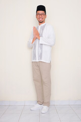 Full body portrait of Moslem man smiling friendly do greeting pose