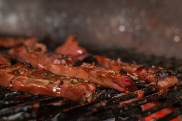 A close-up of burning barbecue coals and lamb liver slices. Lamb liver on the grill. 