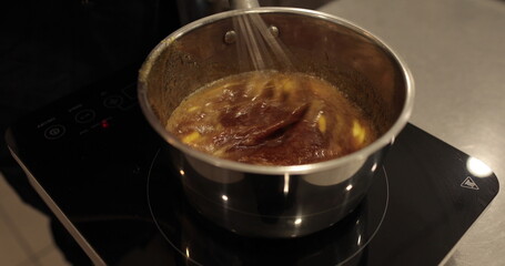 Adding and mixing butter to chocolate mousse to make a dessert. Chocolate preparation, professional kitchen, baking, confectionery